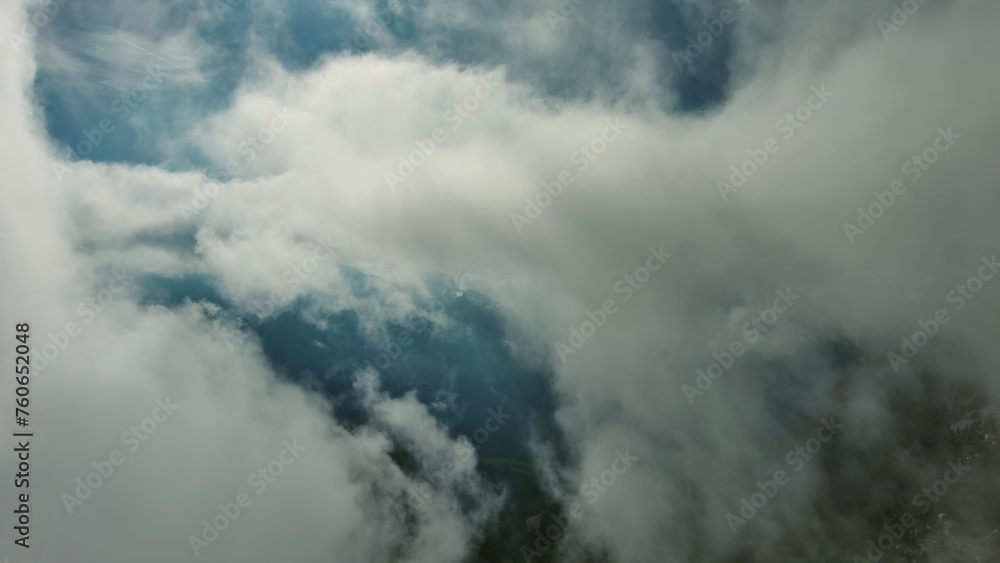 Obraz premium Flying through clouds between mountains