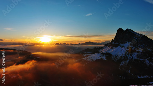 Rocky snow mountains and sunrise sun