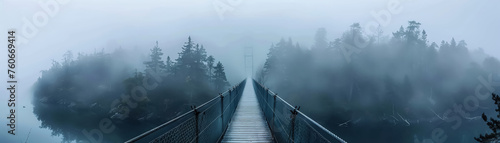a lone suspension bridge in a foggy landscape photo