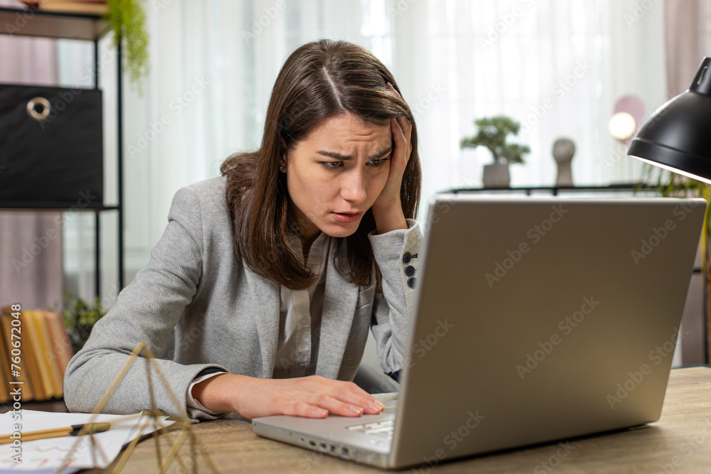 Caucasian young business woman using laptop typing browsing, loses becoming surprised sudden lottery results, bad news, fortune loss fails at home office table workplace. Upset girl freelancer worker Caucasian young business woman using laptop typing browsing, loses becoming surprised sudden lottery results, bad news, fortune loss fails at home office table workplace. Upset girl freelancer worker