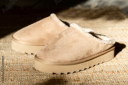 A pair of Uggs slippers on a jute rug. photo