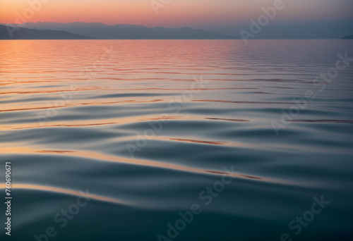 A gently undulating ocean surface at sunset, with soft ripples creating a calming pattern  © Wizard