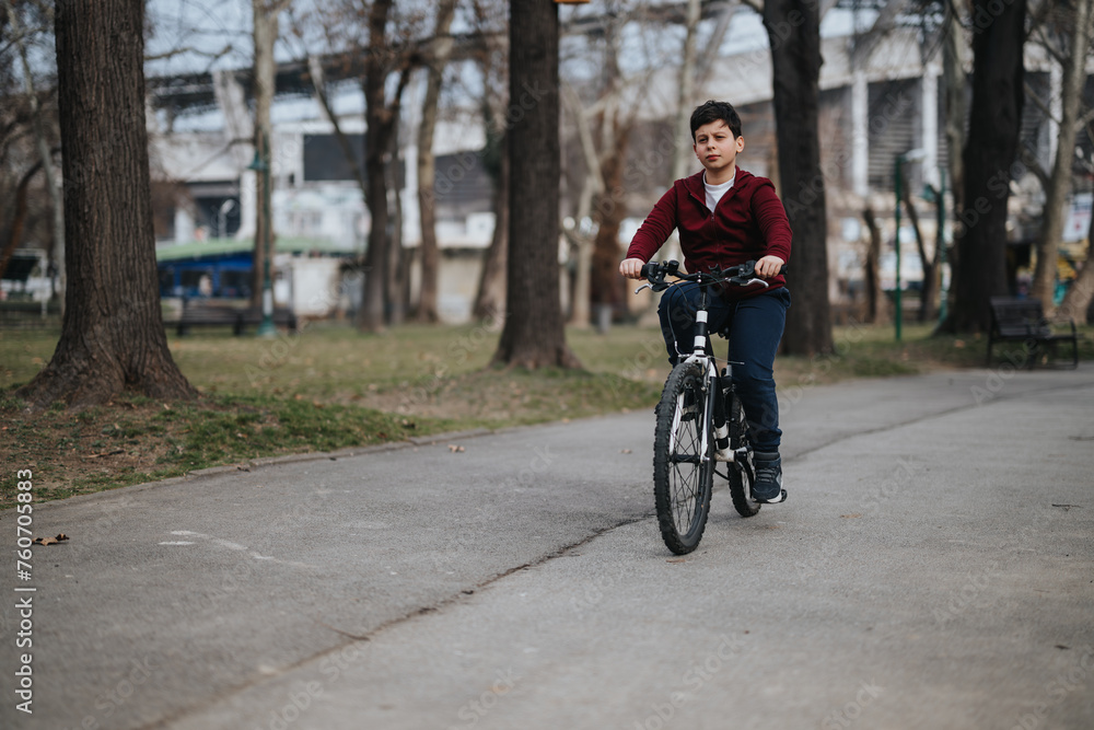 A young boy rides his bicycle through a city park, embracing freedom and joy in a moment of healthy leisure activity outdoors.