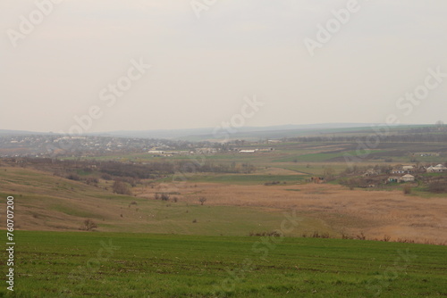 A grassy field with a town in the distance
