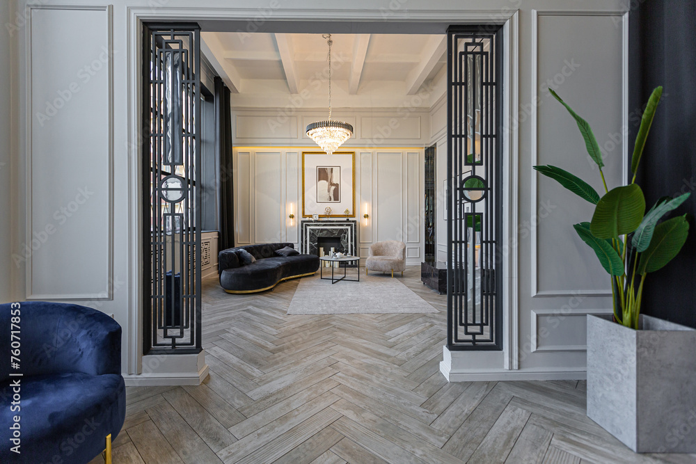 Fototapeta premium stylish cozy light bright luxurious spacious interior of a country house white walls with ornaments, fireplace, work area and recreation area without people during the day