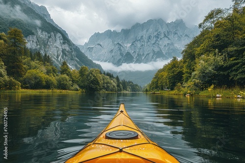The bow of a yellow kayak navigates a calm lake reflecting the mountainous landscape and cloudy skies. a serene kayaking trip on a mirror-like lake © evgenia_lo