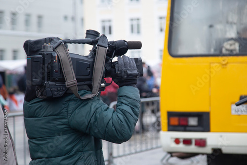 Obraz na płótnie An operator with a video camera takes pictures on a city street.