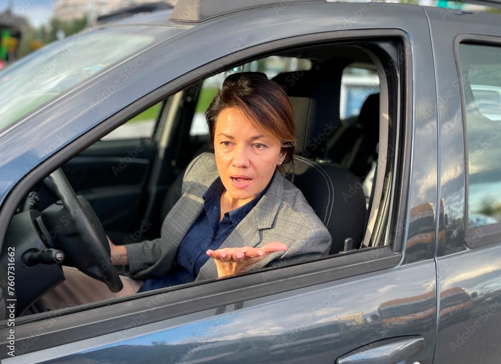 Close up of Caucasian pretty woman sitting in auto looking through window with pretentious face expression. Traffic. Woman driver unhappy with road trip. Trip concept