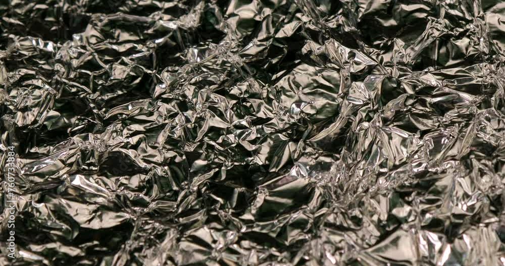 Background with silver wrinkled aluminium foil in rotating motion Background with silver wrinkled aluminium foil in rotating motion