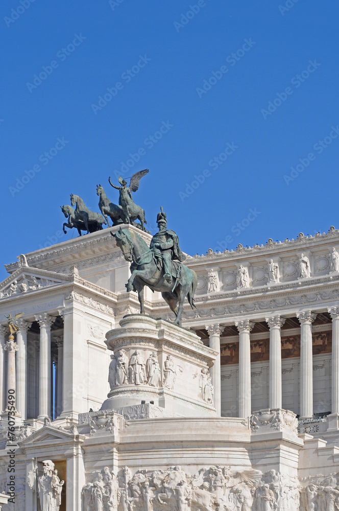 Bronze statue of Vittorio Emanuele II on his horse in front of the Vittoriano or Altar of the Fatherland on Piazza Venezia (Venice Square) in Rome with blue sky