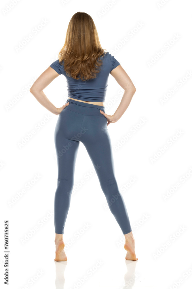 Full body, rear view young woman in sportswear posing on white background Full body, rear view young woman in sportswear posing on white background