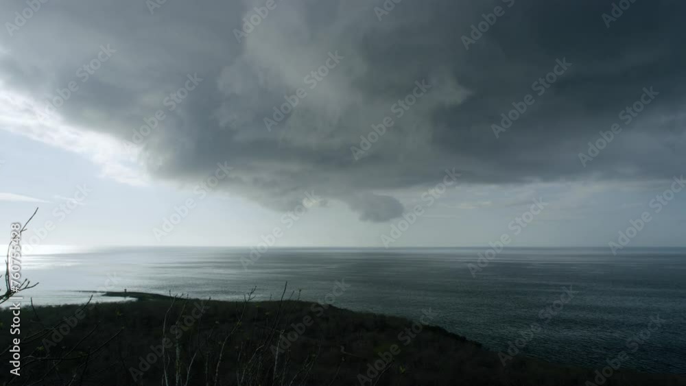 Dreadful dark grey clouds moving fast above the shore. Dreadful dark grey clouds moving fast above the shore.