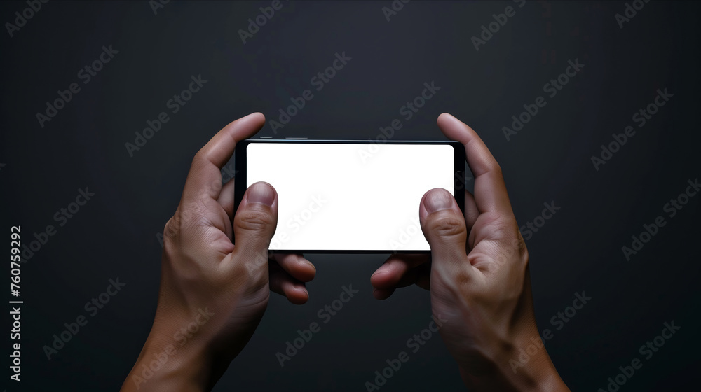 A man is holding a smartphone with blank screen. The fingers are gripping the phone tightly, indicating the person is engaged with the device, video game or app A man is holding a smartphone with blank screen. The fingers are gripping the phone tightly, indicating the person is engaged with the device, video game or app