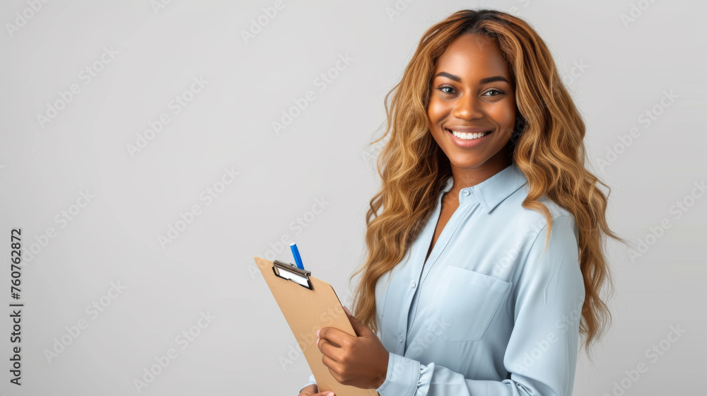 smiling young woman with long wavy hair, wearing a light blue button-up shirt smiling young woman with long wavy hair, wearing a light blue button-up shirt
