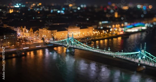 Budapest, Hungary - February 7, 2024: Landscape view of night Budapest from Citadella observation deck. Focus tilted to Fovam Ter street. Liberty bridge and Central Market on the middleground. photo