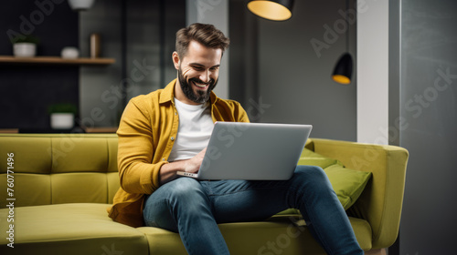 A man in a casual outfit works on a laptop in his office