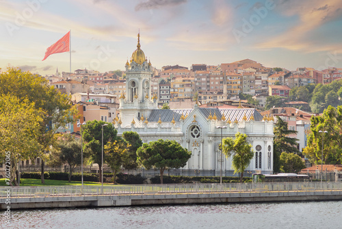 View from Golden Horn of Neo Byzantine architecture style Bulgarian St. Stephen Church, a Bulgarian Orthodox church in Balat district, Istanbul, Turkey, with Turkish flag in the far end photo