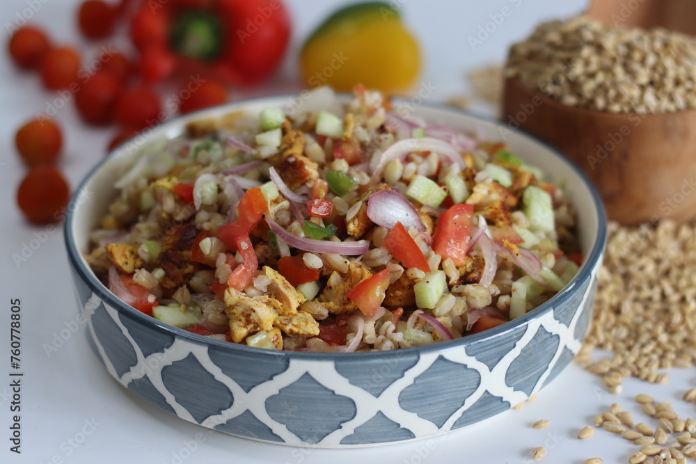 Hulled barley chicken salad. Hearty salad with hulled barley, chicken, cucumber, tomato, onions in a ceramic bowl Hulled barley chicken salad. Hearty salad with hulled barley, chicken, cucumber, tomato, onions in a ceramic bowl