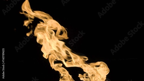 Slow-motion video of fire and flames.A fire pit, burning gas or gasoline burns with fire and flames.Flames and burning sparks close-up,fire patterns.A hellish glow of fire in the dark with copy space photo