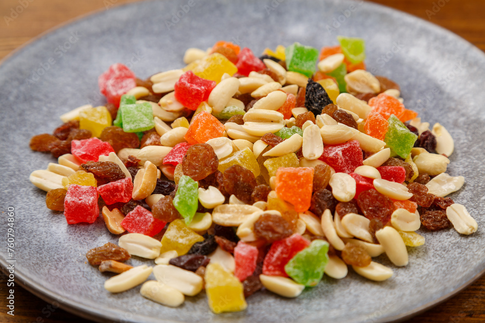 Mix of dried fruits and nuts on a gray plate. horizontal
