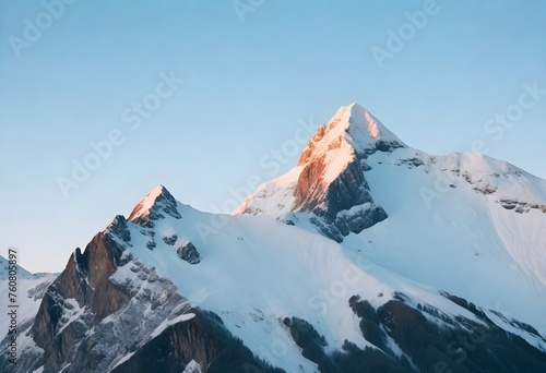Snow-covered mountain peaks during sunset with a clear sky