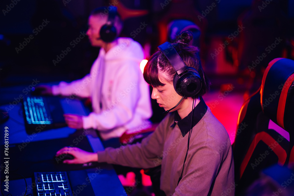 eSports female gamer playing online strategy video game in an internet cafe eSports female gamer playing online strategy video game in an internet cafe