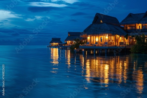 Exotic tropical resort at dusk With illuminated villas over water Offering a picturesque setting for a luxurious getaway.