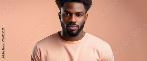 Banner, close up portrait of a black man with peach fuzz color shirt on a pastel peach background studio shot photo