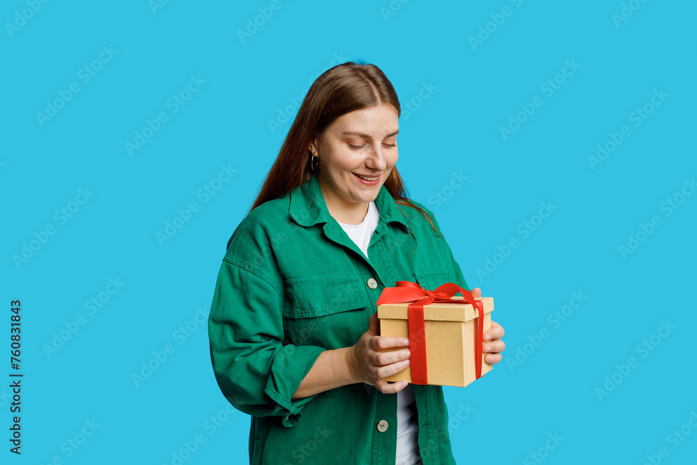 Portrait of cheerful, happy 30s woman receive gift, smiling excited. Girl holding wrapped present, celebrating birthday on blue background. Valentine's Day Women's Day birthday holiday concept. Portrait of cheerful, happy 30s woman receive gift, smiling excited. Girl holding wrapped present, celebrating birthday on blue background. Valentine's Day Women's Day birthday holiday concept.