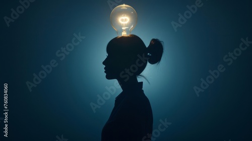 Female Entrepreneurship Symbol: A silhouette of a female entrepreneur with a lightbulb overhead,  representing innovation and leadership in business photo