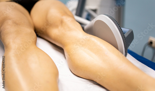 An adult man undergoes super inductive system therapy for recovery from trauma and rheumatic pathologies in a physiotherapy clinic.The handle is in the calf of the leg. Super Inductive System, SIS. photo