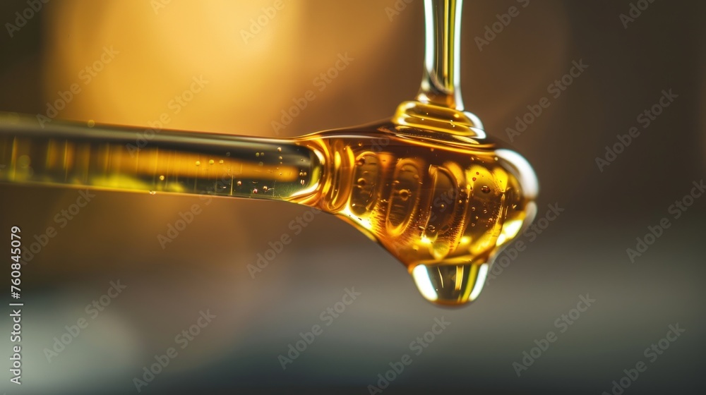 a close up of a drop of honey from a faucet that is dripping from a faucet. a close up of a drop of honey from a faucet that is dripping from a faucet.