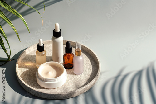 Skin care essence serum bottles with dropper and face cream on marble cosmetic tray on light background. Vitamins for skin. Hydrating anti aging serum and cream with collagen and peptides. Cosmetics