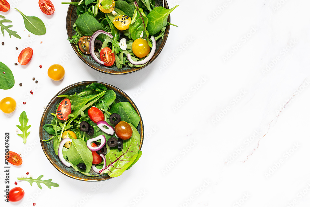 Fresh green spring salad on white marble table top view, healthy diet food concept.
Fresh green spring salad on white marble table top view, healthy diet food concept.