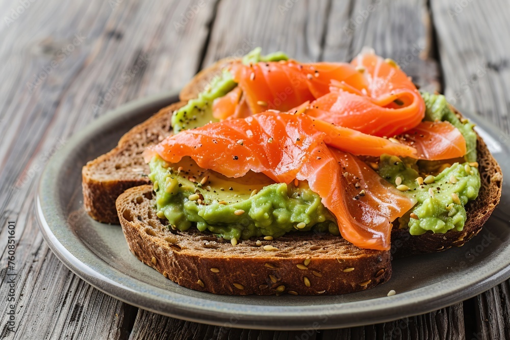 Toast bread with salted salmon and guacamole avocado in plate on wooden table Toast bread with salted salmon and guacamole avocado in plate on wooden table