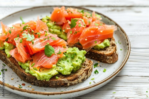 Toast bread with salted salmon and guacamole avocado on wooden table