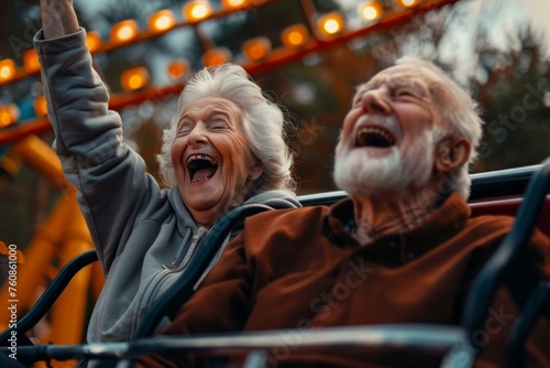 Funny elderly crazy retired grandparents together riding on roller coaster in amusement park, active old age