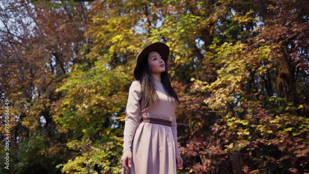 Twilight tranquility. Woman in wide-brimmed hat wanders amidst autumn's embrace Twilight tranquility. Woman in wide-brimmed hat wanders amidst autumn's embrace