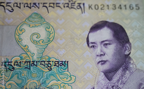 Closeup portrait of King Jigme Singye Wangchuck on old Ngultrum Bhutan currency banknote photo