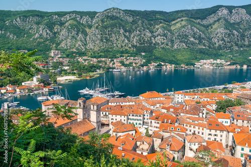 Aerial view of Kotor old town with orange rooftops and marina in Kotor bay with boats and yachts, Montenegro. Summer vacation resort on Adriatic fjord in summer day. Travel destination photo