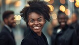 Portrait of beautiful black businesswoman wearing suit and tie smiling in urban background. Woman with afro hairstyle.