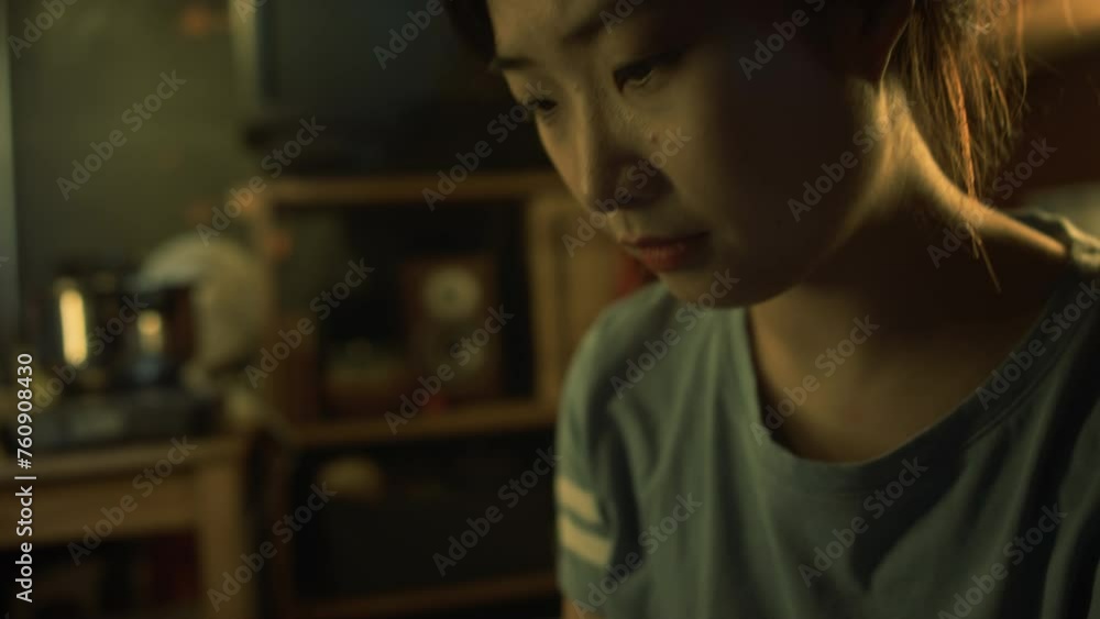 Close-up tilting down shot of concentrated face and hands of young Korean or Chinese girl drawing something in sketchbook in dark cluttered micro apartment, steaming pot on cooking stove in background Close-up tilting down shot of concentrated face and hands of young Korean or Chinese girl drawing something in sketchbook in dark cluttered micro apartment, steaming pot on cooking stove in background