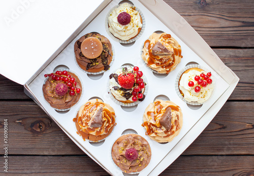 Vanilla, chocolate and peanut butter cupcakes with salted caramel, fresh raspberry, strawbeery and red currant in gift paper box photo