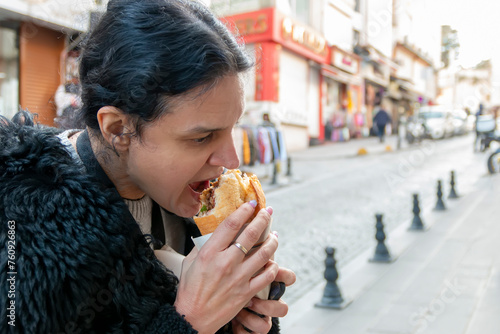 Experiencing street food. A woman  is on vacation and tries out street food  in a tourist side street at a local street vendor selling food