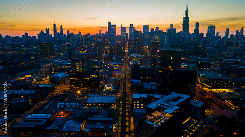 A captivating aerial view of a cityscape at dusk  showcasing illuminated skyscrapers against the darkening sky. The golden hues of sunset paint a serene backdrop  highlighting architectural marvels