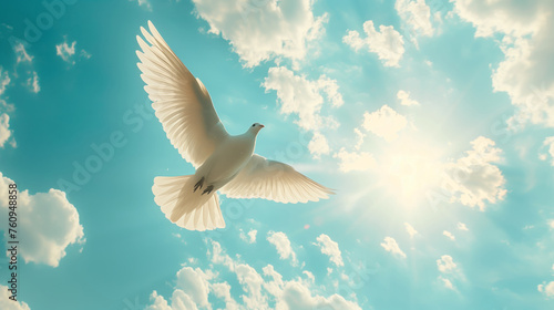 A white dove flies in the sky above a blue and white cloud © kitti
