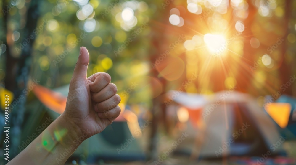 Fototapeta premium Thumbs up sign. Woman's hand shows like gesture. Camping background