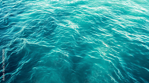 Sunlight sparkles on the deep teal ocean, creating a mesmerizing pattern of light and shadow on the water's surface.