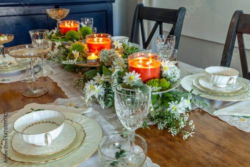 Formal table set with daisies, peach candles, and fine China plates