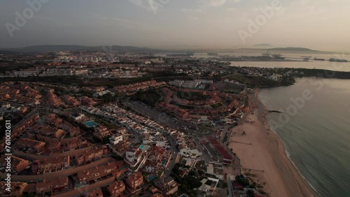 slow-motion aerial sideways video on Algeciras City in spain with landscape view of city and commercial harbor during sunrise photo